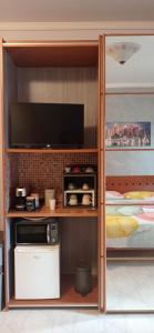 a room with a tv and a microwave and a bed at Casa Melo in Ciampino