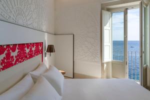 Schlafzimmer mit einem Bett und Meerblick in der Unterkunft Maniace Boutique Hotel Ortigia | UNA Esperienze in Syrakus