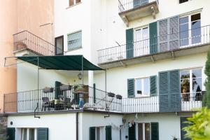 een gebouw met een groene parasol op een balkon bij Appartamento Gino in Cannero Riviera