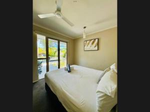 una camera con letto e ventilatore a soffitto di Reef Terraces on St Crispins a Port Douglas