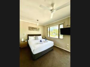 una camera con un grande letto e un ventilatore a soffitto di Reef Terraces on St Crispins a Port Douglas