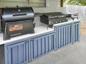 a grill and a smoker on a outdoor table at Skyes Beach House - The entertainer - Pet Friendly in Malua Bay