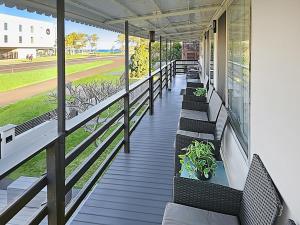 eine Veranda mit Bänken und Blick auf ein Baseballfeld in der Unterkunft Skyes Beach House - The entertainer - Pet Friendly in Malua Bay