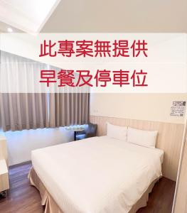 een slaapkamer met een wit bed in een kamer bij M Hotel in Kaohsiung