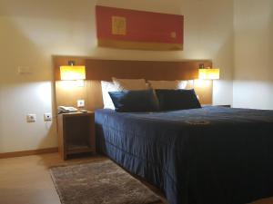 una camera con un letto con due lampade e un telefono di Hotel Jose Alberto a Viseu