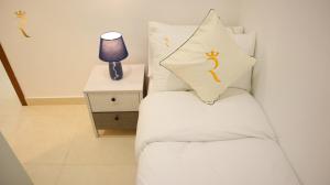 Una cama blanca con una almohada encima. en Elegant 2BR Golf View Oasis with Maids Room in Yas Island, en Yas Island