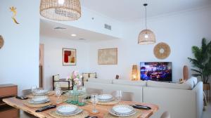 comedor con mesa y sofá en Elegant 2BR Golf View Oasis with Maids Room in Yas Island, en Yas Island