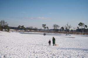 Eine Frau und ein Kind stehen auf einem schneebedeckten Strand in der Unterkunft Camping Marvilla Parks Kaatsheuvel - Roan in Kaatsheuvel