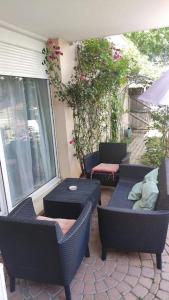 een patio met 2 stoelen, een tafel en een parasol bij Appartement de 51 m2 avec jardin de 51 m2, parking privé in Achères