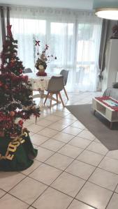 een woonkamer met een kerstboom op een tegelvloer bij Appartement de 51 m2 avec jardin de 51 m2, parking privé in Achères