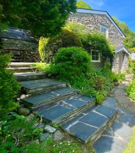 Llanbedr-y-cenninYr Hen Efail Cosy 1 bedroom Cottage, with fireplace and garden的一座花园,房子前有一条石头走道