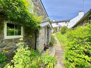 Llanbedr-y-cenninYr Hen Efail Cosy 1 bedroom Cottage, with fireplace and garden的石头房子,有一条通往院子的路径