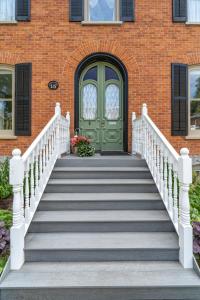 a staircase leading to a door with a green door at The 1885 Suites in Picton