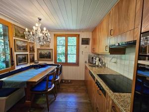 eine Küche mit Holzschränken und eine große Insel mit blauen Stühlen in der Unterkunft Chalet Tannegüetli in Grindelwald