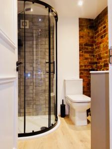 uma casa de banho com um WC e uma cabina de duche em vidro. em Newly Renovated Stunning Warehouse Apartment em Bournemouth