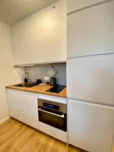 ブラチスラヴァにあるnook I SkyNest Apartmentsのキッチン(白いキャビネット、コンロ付)