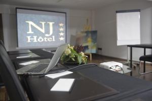 een laptop op een bureau met een monitor bij NJ Hotel Rabat in Rabat