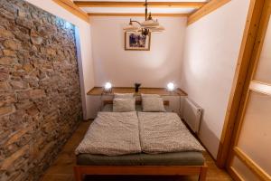 Habitación con 2 camas y pared de piedra. en Apartmány Paradajs, en Spišská Nová Ves