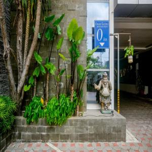 Eine Statue eines Mannes vor einem Gebäude in der Unterkunft Sans Hotel Grand Omah Sastro in Yogyakarta