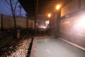 een zwembad met water naast een gebouw 's nachts bij Wakamatsuya in Zao Onsen