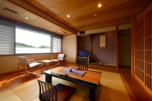 een kamer met een tafel en stoelen en een televisie bij Wakamatsuya in Zao Onsen