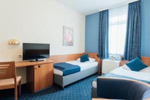 um quarto de hotel com duas camas e uma televisão de ecrã plano em Hotel Commerz Hamburg em Hamburgo