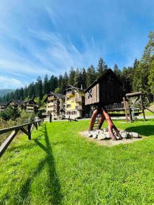 um parque infantil num campo com um edifício de madeira em Apartmán Olívia 8 Hrabovská dolina em Ružomberok