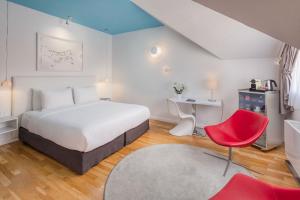 een slaapkamer met een bed en een rode stoel bij Casati Hotel - Adults Only in Boedapest