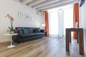 a living room with a black couch and a table at Relais Santa Corona in Vicenza