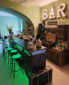 um bar com bancos de bar verdes e uma placa que diz "assar" em Green Spirit Hotel em Regensburg