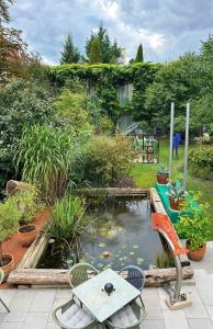 um jardim com um lago com uma mesa e cadeiras em Green Spirit Hotel em Regensburg