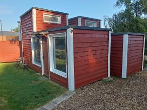 ein kleines Haus mit roter Seite auf einem Hof in der Unterkunft Gästehaus Maria Rast in Suderburg