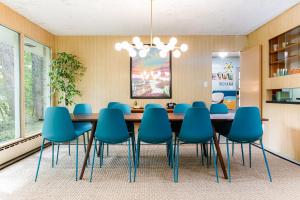 uma sala de jantar com uma mesa e cadeiras azuis em Unique! Retro 1950's wooded retreat near Indiana Dunes National Park em Chesterton