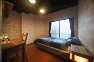 um quarto com uma cama, uma secretária e uma janela em 045 Hostel Yoshidamachi em Yokohama