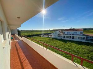 uma varanda de uma casa com vista para uma quinta em Beach House-5 Minutos a pé da praia na Manta Rota