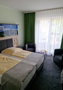 Habitación de hotel con 2 camas y cortinas verdes en AKZENT Hotel Zur Post, en Tabarz