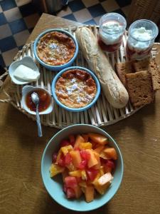 a table with bowls of fruit and bread and dips at Villa Giselle in Hayange