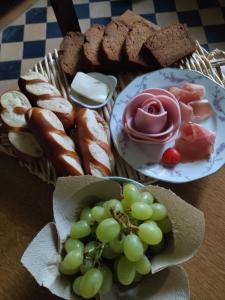 a table with two plates of bread and a bowl of grapes at Villa Giselle in Hayange