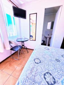 a bedroom with a bed and a table and a tv at Habitacion y Baño Privado in La Serena