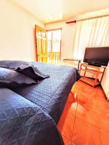 a bedroom with a bed and a flat screen tv at Habitacion y Baño Privado in La Serena