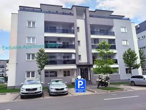 two cars parked in a parking lot in front of a building at Exclusive Apartment SIBIU in Sibiu