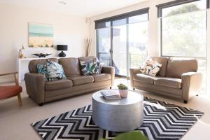 a living room with two couches and a coffee table at Torquay Golf Retreats - Pool, Beach, Tennis, Golf in Torquay