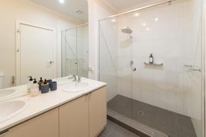 a bathroom with two sinks and a shower at Torquay Golf Retreats - Pool, Beach, Tennis, Golf in Torquay