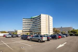 um parque de estacionamento com carros estacionados em frente a um edifício em Holiday Inn Melbourne Airport, an IHG Hotel em Melbourne