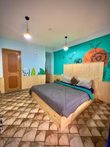 een slaapkamer met een bed met een schilderij aan de muur bij Hostel 360 Degree in Manāli