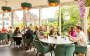 un gruppo di persone seduti ai tavoli in un ristorante di De Maasparel Nextdoor Maassuites ad Arcen