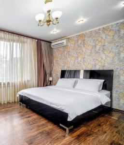 Lux Apartment Gorkiy Park في خاركوف: غرفة نوم بسرير كبير وثريا