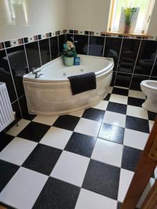 ein Bad mit einer Badewanne und einem WC in der Unterkunft Benroe House 5 Bedrooms in Killybegs