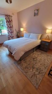 ein Schlafzimmer mit einem großen Bett und einem Teppich in der Unterkunft Benroe House 5 Bedrooms in Killybegs