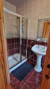 ein Bad mit einer Dusche und einem Waschbecken in der Unterkunft Benroe House 5 Bedrooms in Killybegs